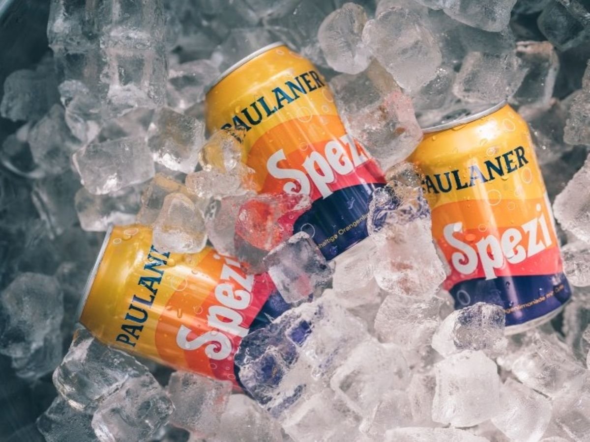 Le iconiche lattine con grafica anni '70 di Paulaner Spezi